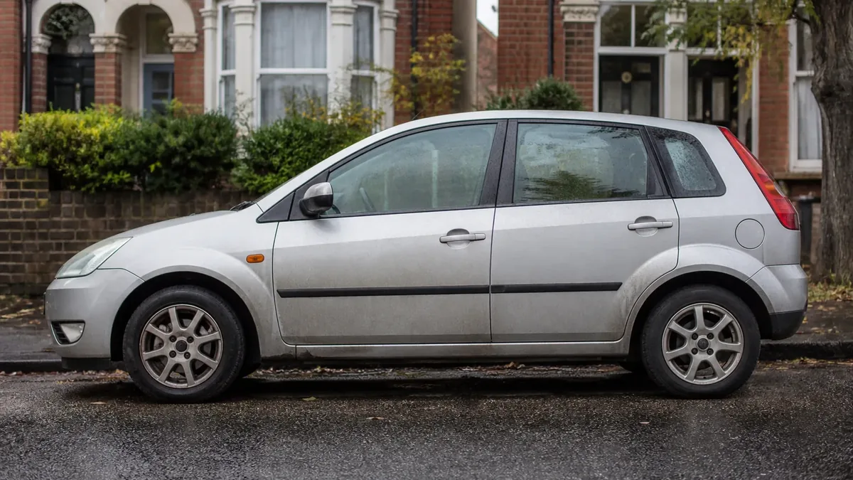 Used hatchback parked on a British residential street under overcast UK daylight